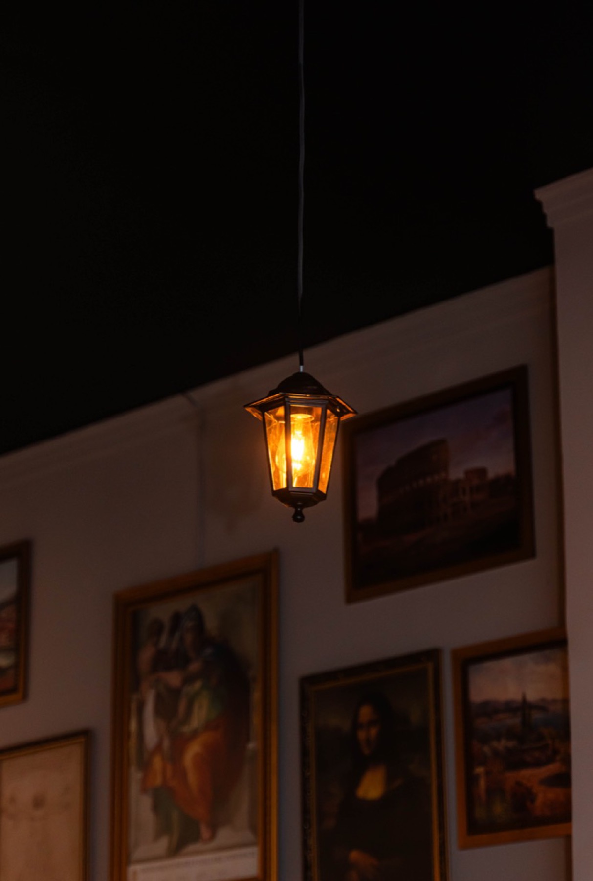 Luminária antiga e quadros no salão
